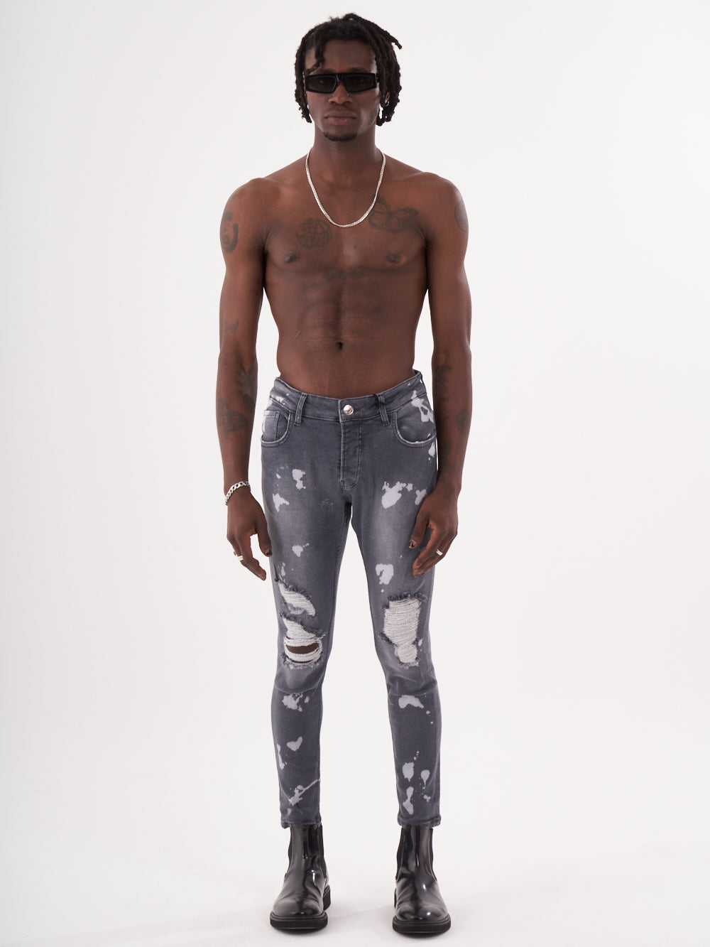 A man wearing the MAVERICK ripped jeans and a t-shirt.