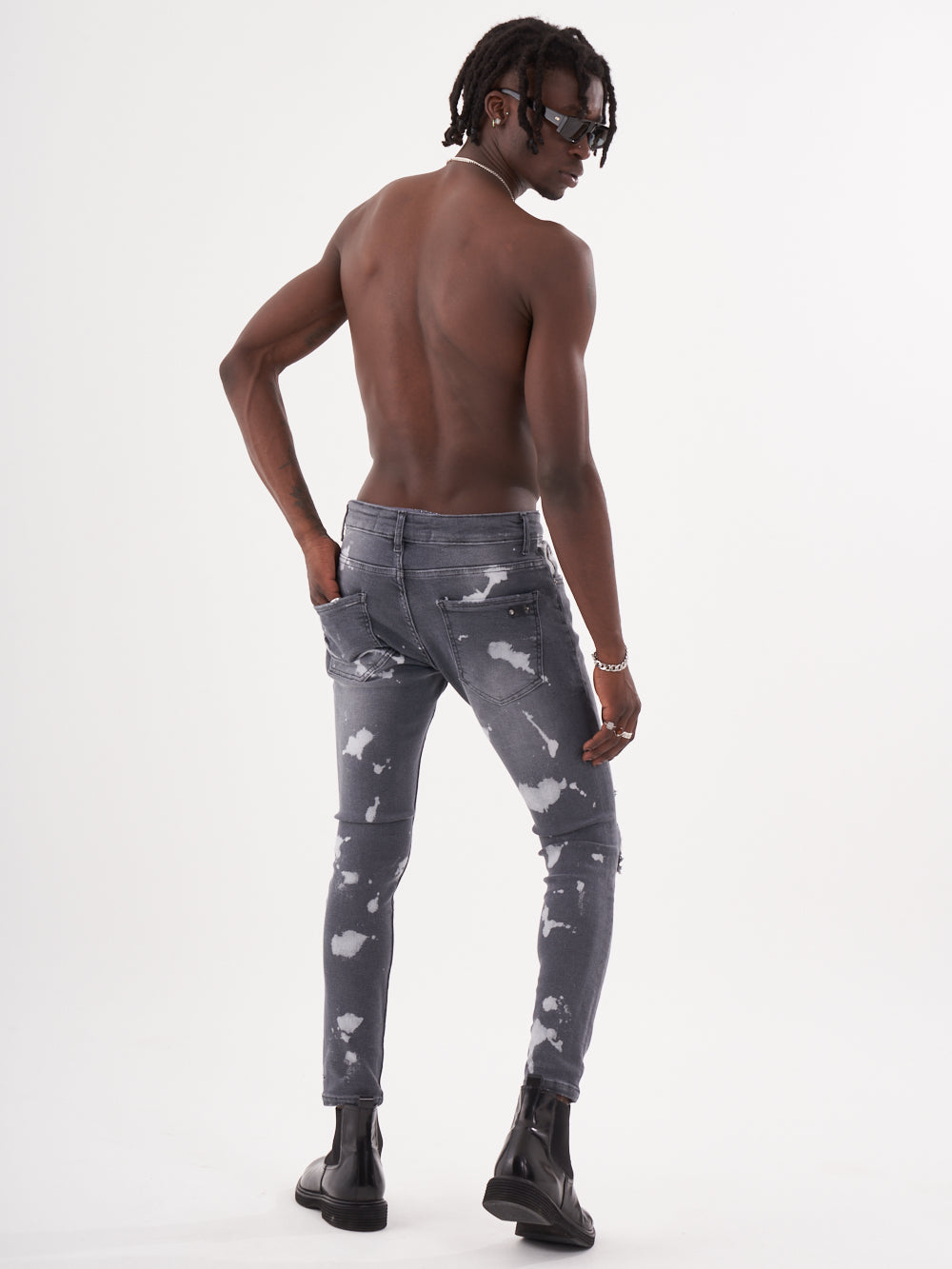 The back of a man wearing grey jeans with MAVERICK pattern.