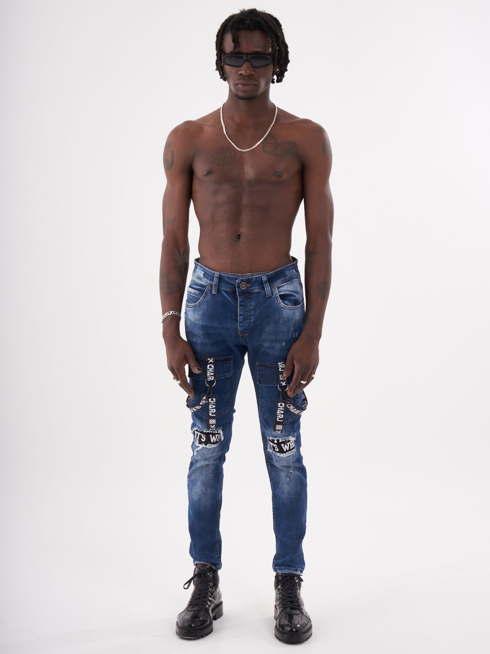 A man with no TORNADO BLUE and no shoes is standing in front of a white background.