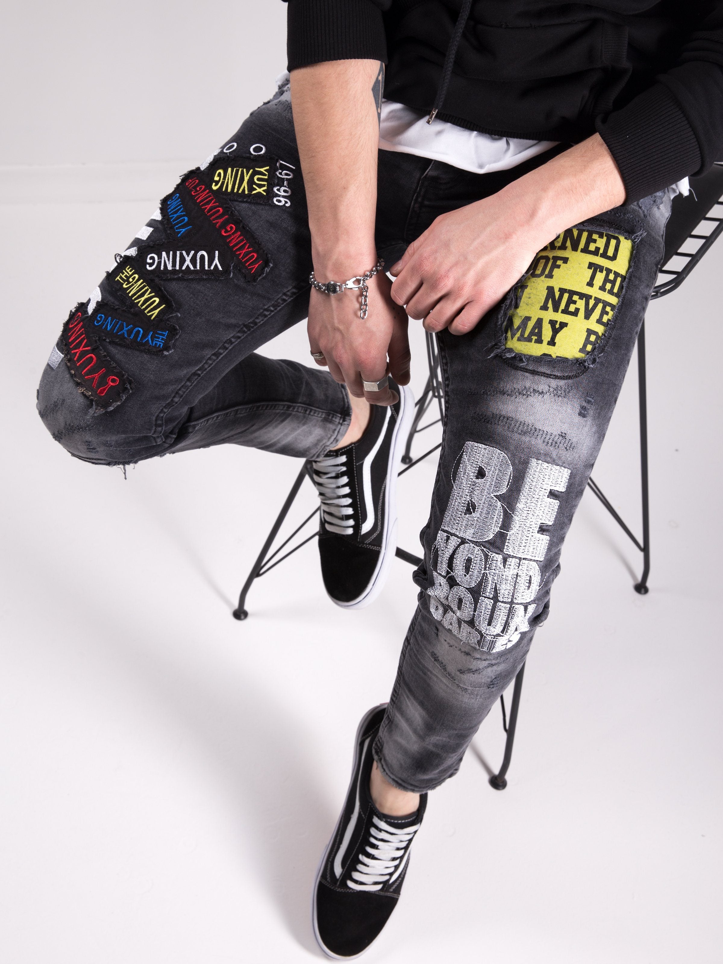 A man is sitting on a chair wearing a pair of SAVAGE SECRET jeans.