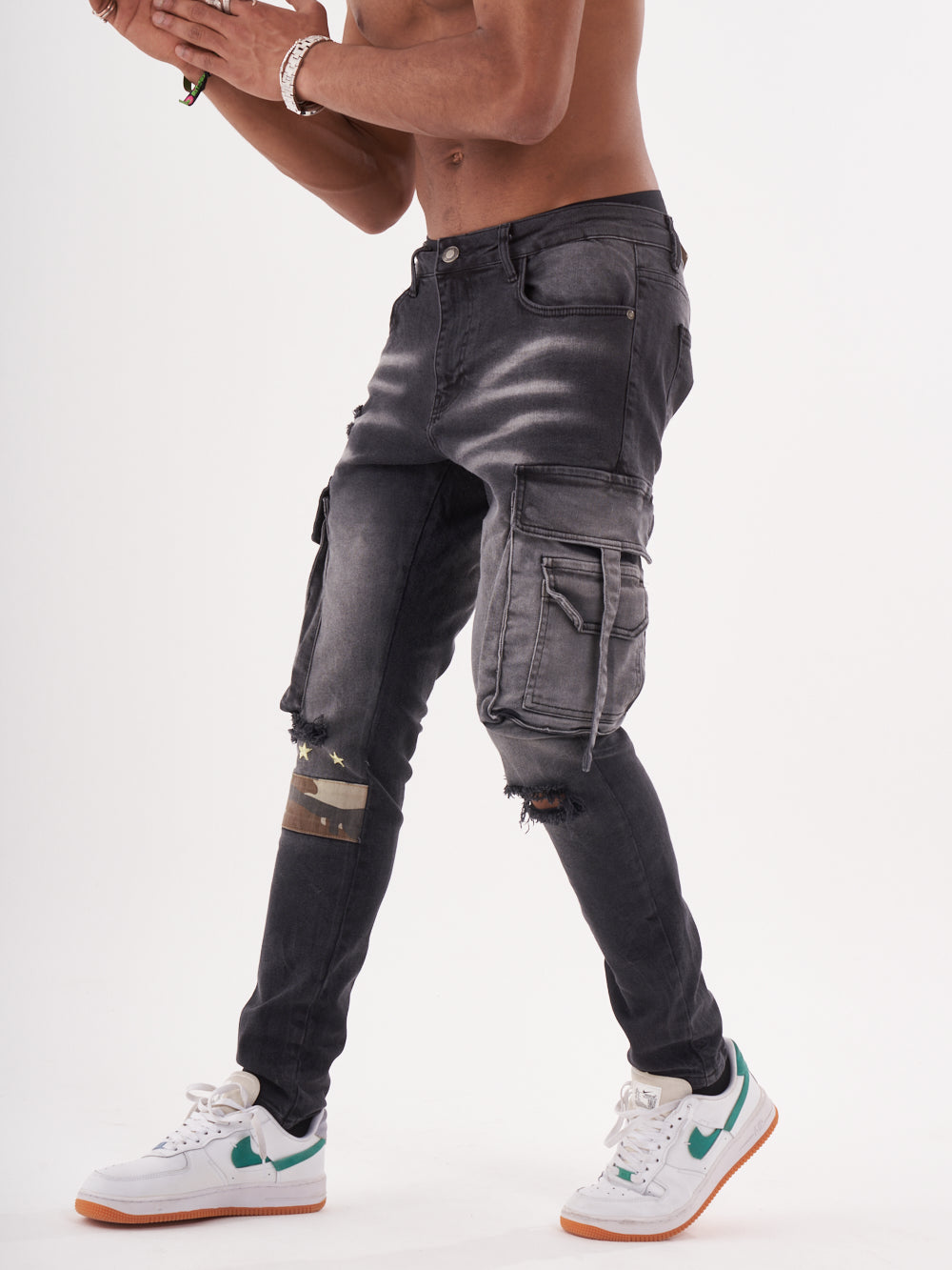 A man in black HIPSTER jeans and a white t-shirt is posing for a photo.