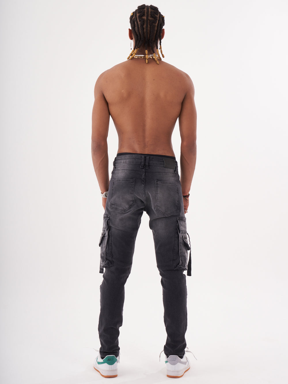 The back view of a man wearing black denim HIPSTER cargo pants.