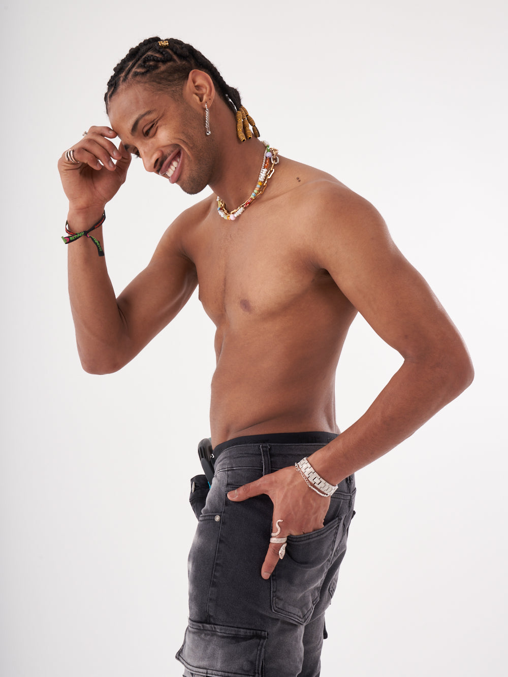 A young man with dreadlocks posing with his hands on his HIPSTER.