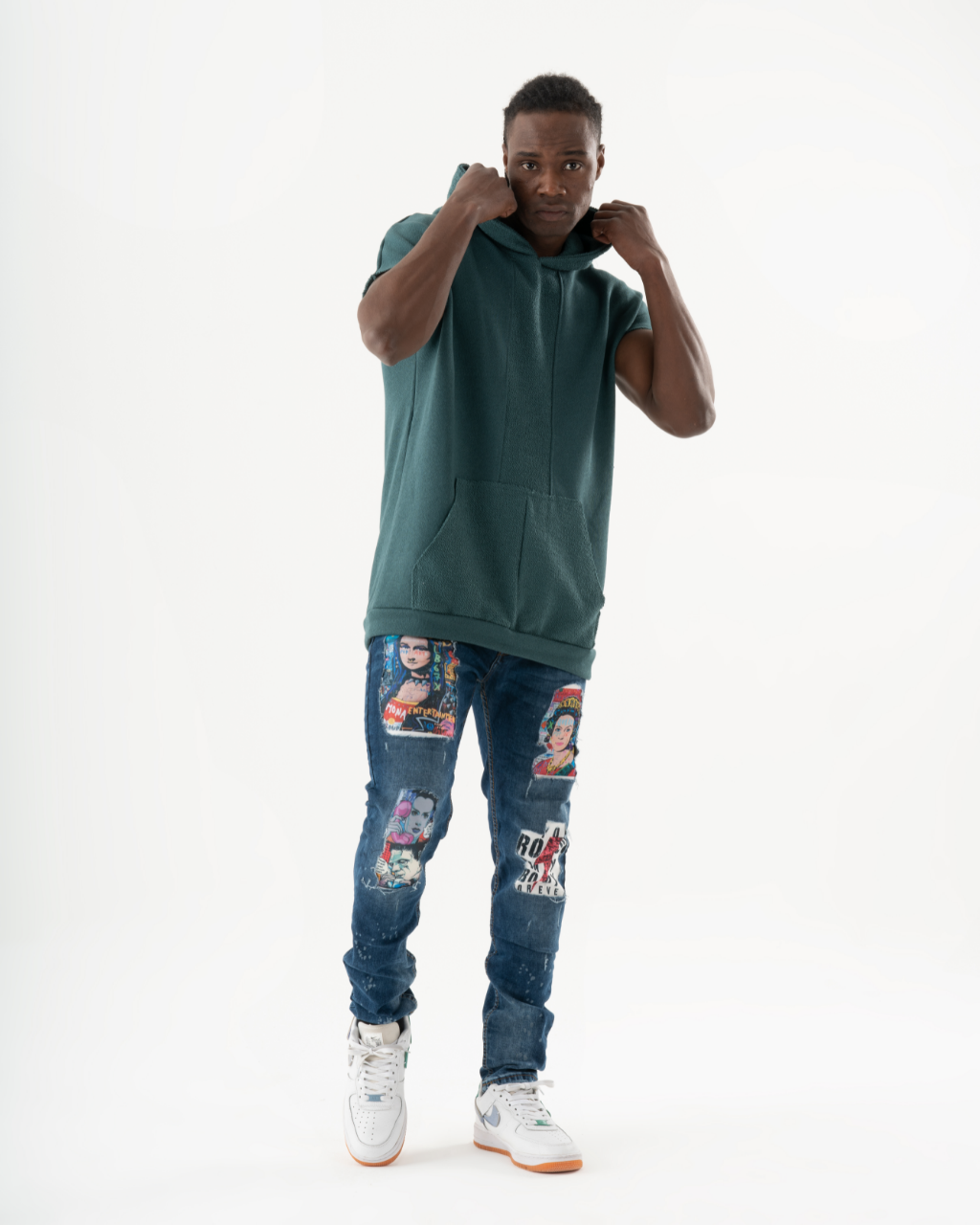 A black man wearing ripped jeans in a green hoodie attends a concert featuring CRESCENDO influences.