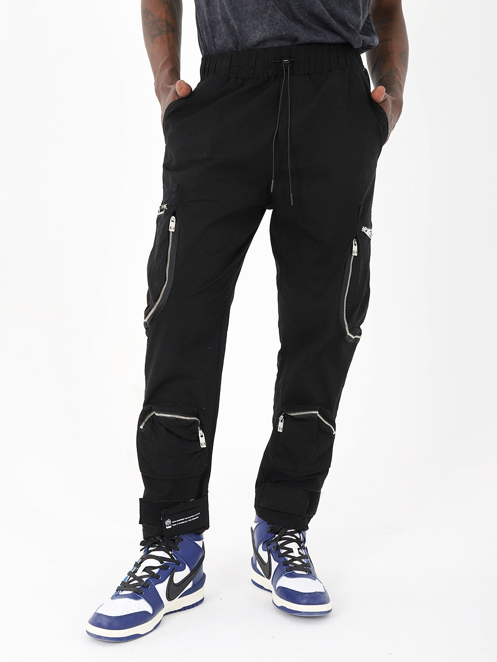 A man wearing Raider jogger pants with zippered pockets.
