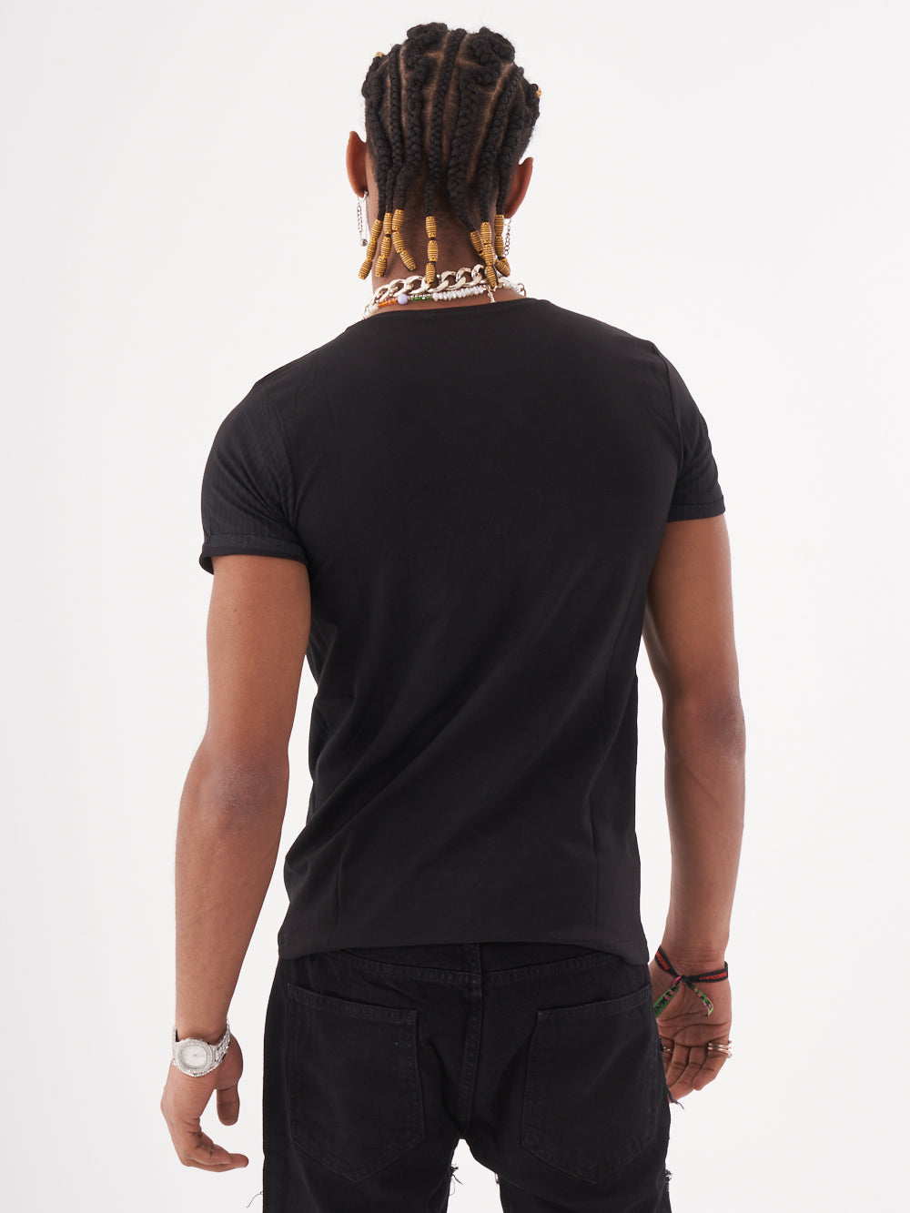 A man wearing a NIRVANA skull-print embellished T-SHIRT in black color with relaxed fit streetwear jeans