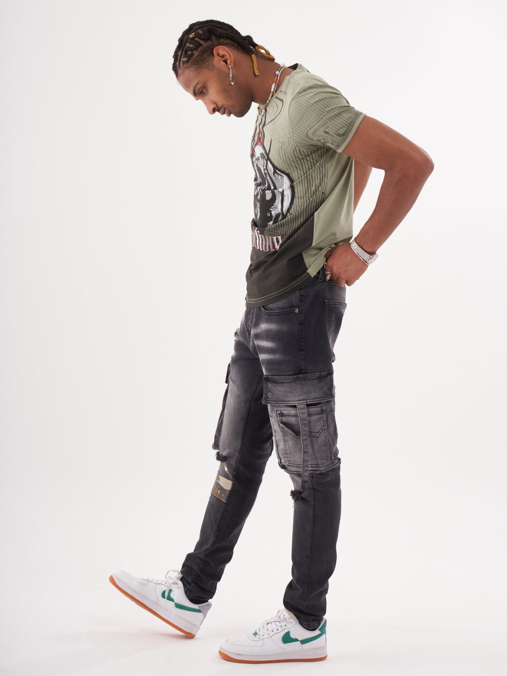 A man wearing a NIRVANA T-SHIRT | GREEN and cargo pants.