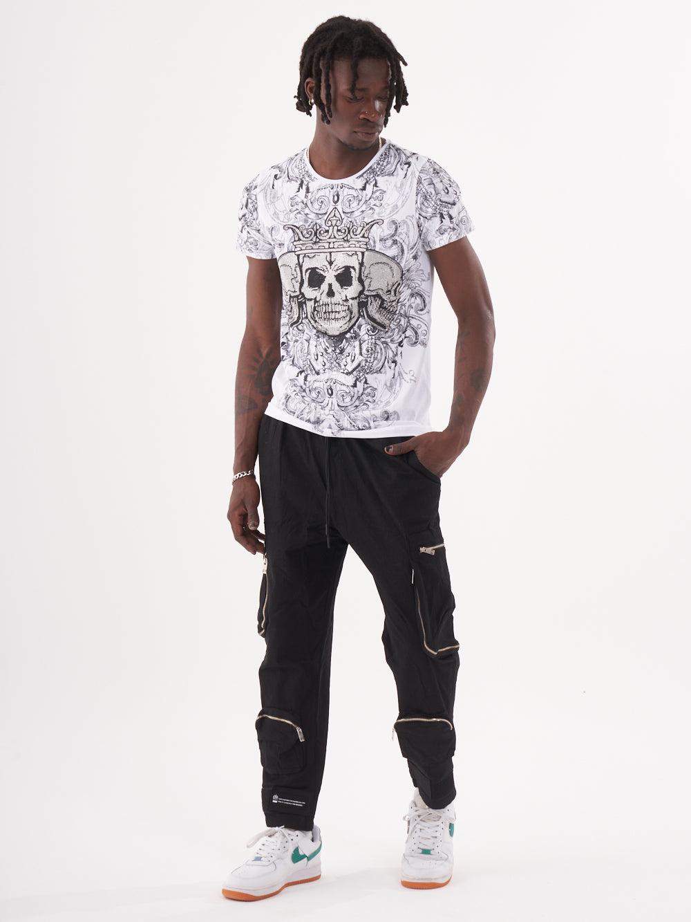 A man with an edgy style, wearing a gothic-inspired TRINITY T-SHIRT | WHITE and black cargo pants.