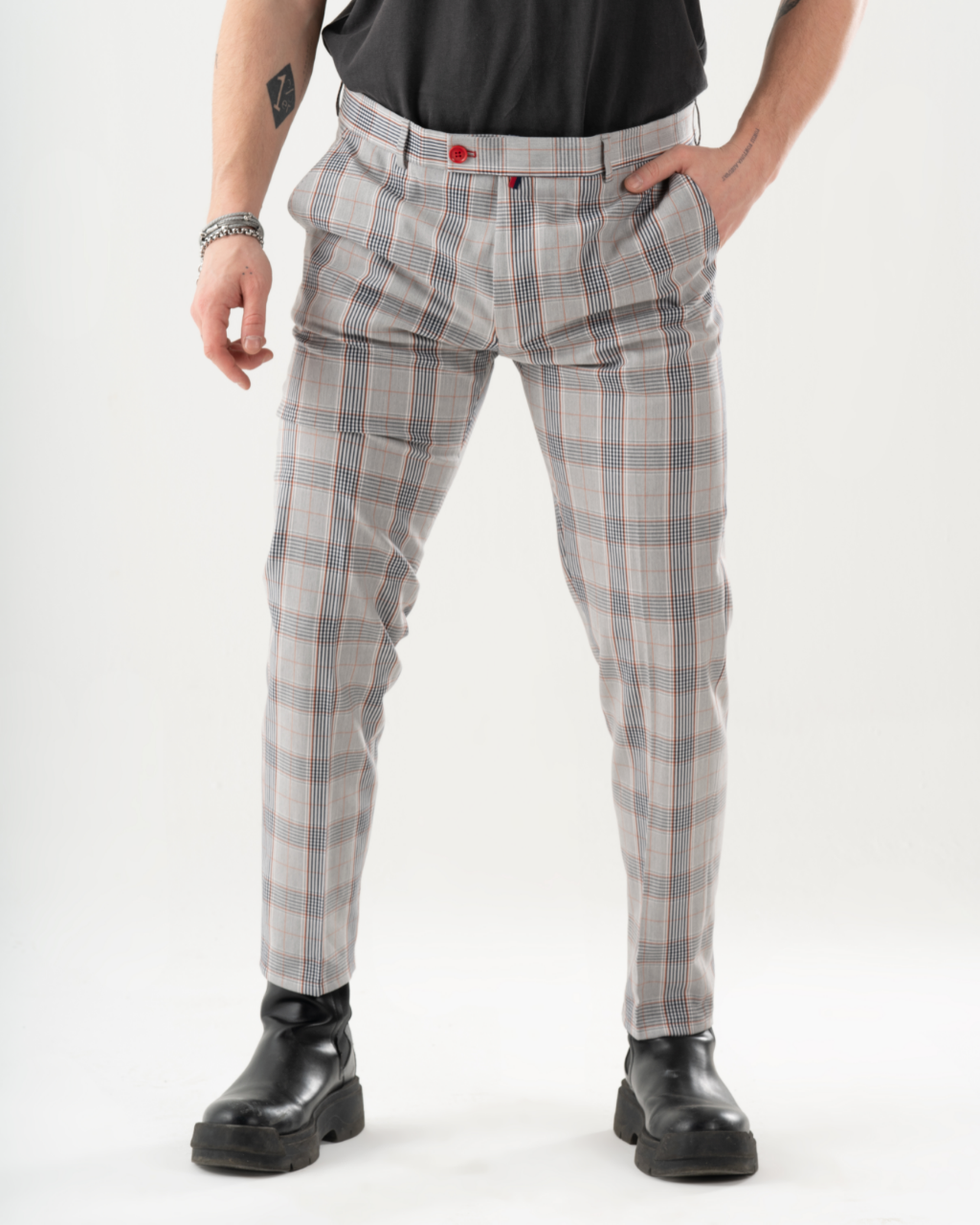 A man in black pants is posing for a photo wearing KIKR PANTS.