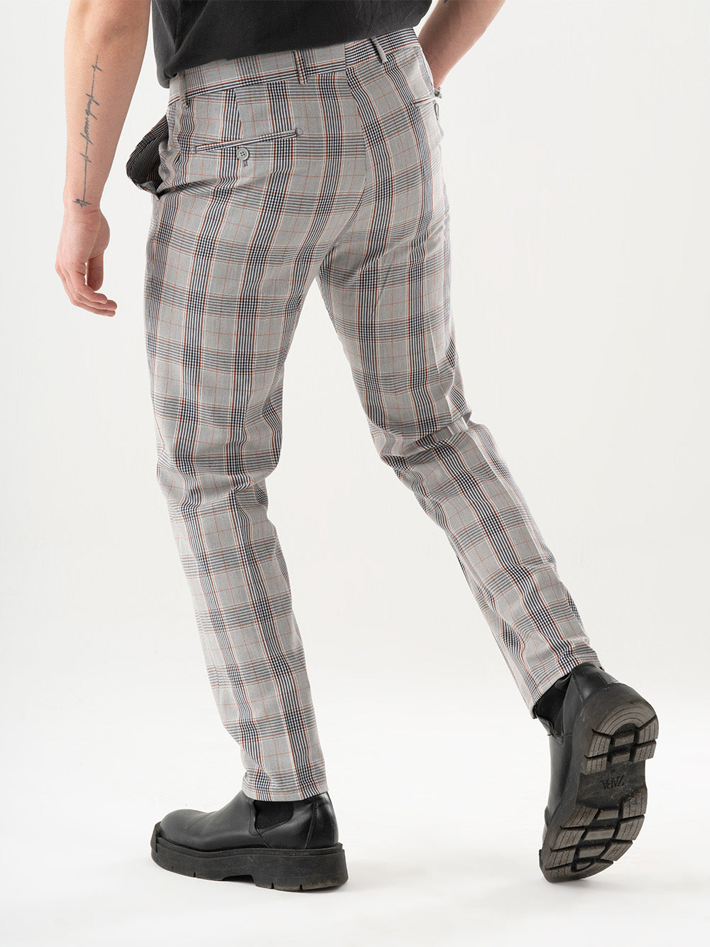 A man is standing with his back to the camera wearing KIKR PANTS.