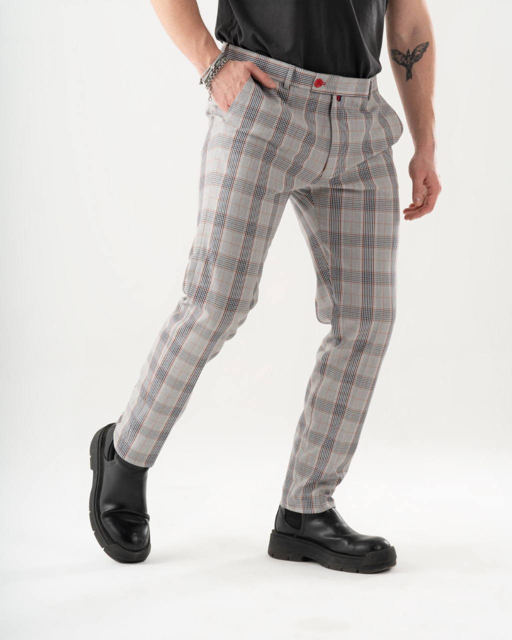 A man in KIKR PANTS is standing in front of a white background.