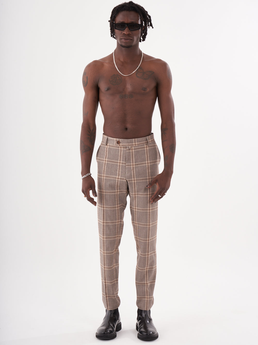 A man with no shirt and ROOK PANTS is standing in front of a white background.