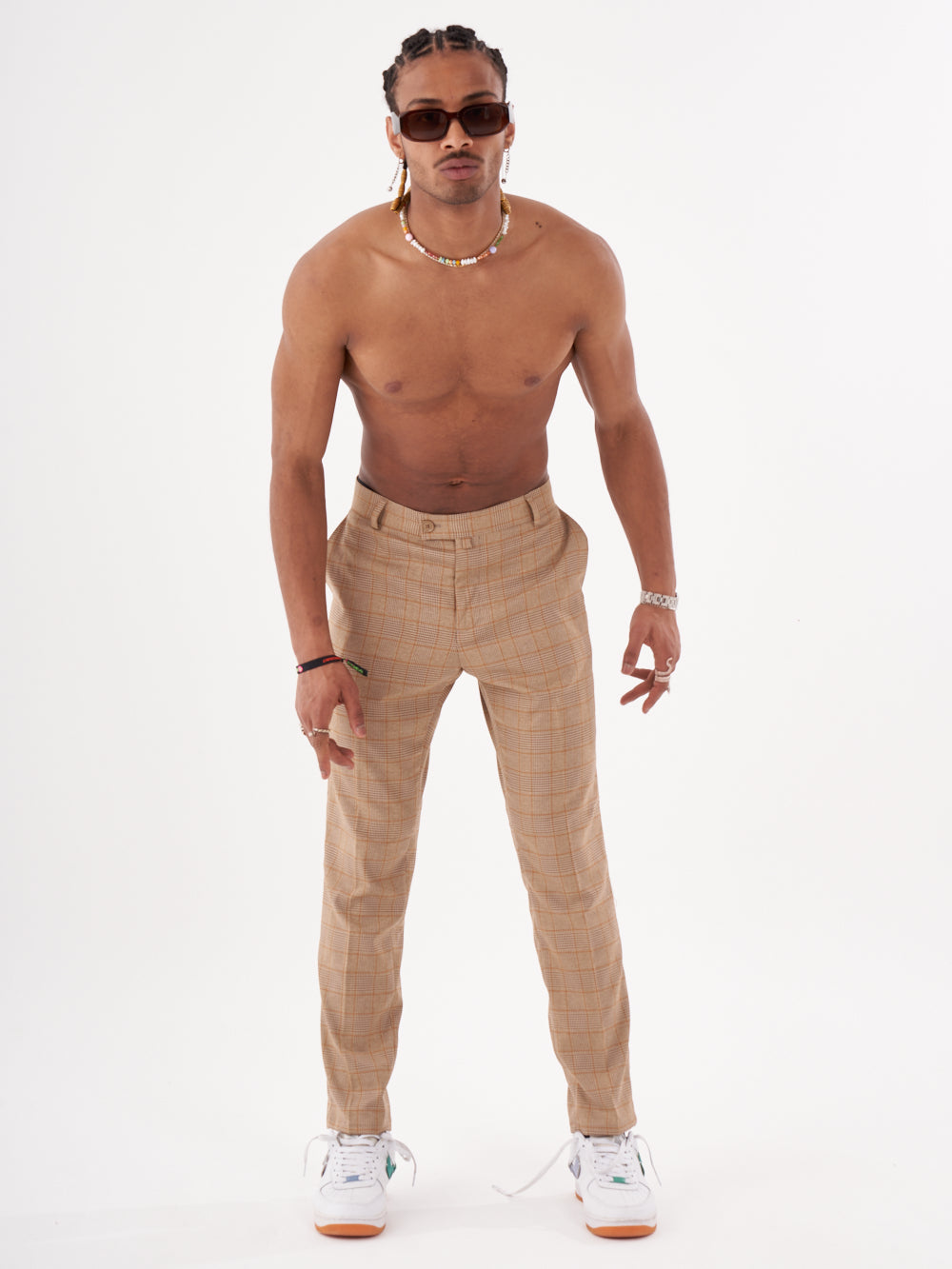 A man in BAROT pants with no shirt and no shoes.