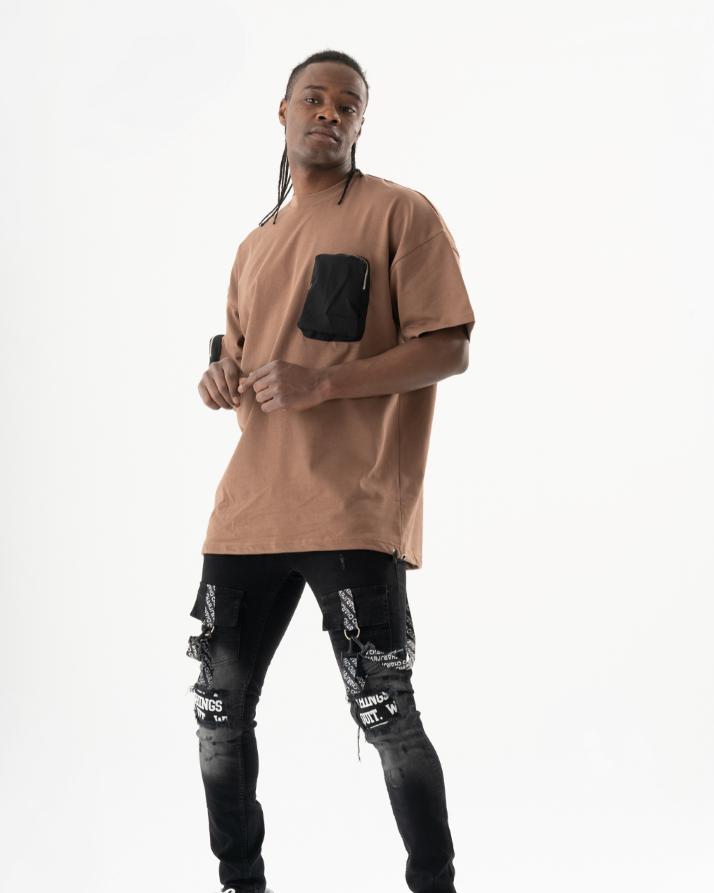 A man wearing a FATE T-SHIRT t - shirt and ripped jeans.