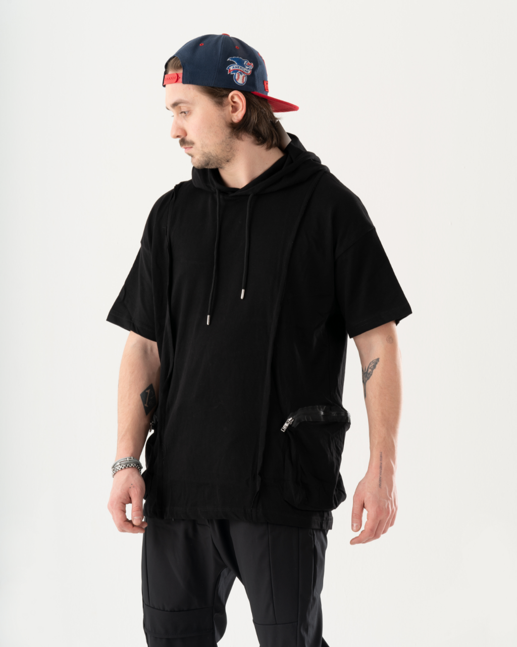 A stylish man donning a sleek BLACKFURY HOODIE and matching black pants.
