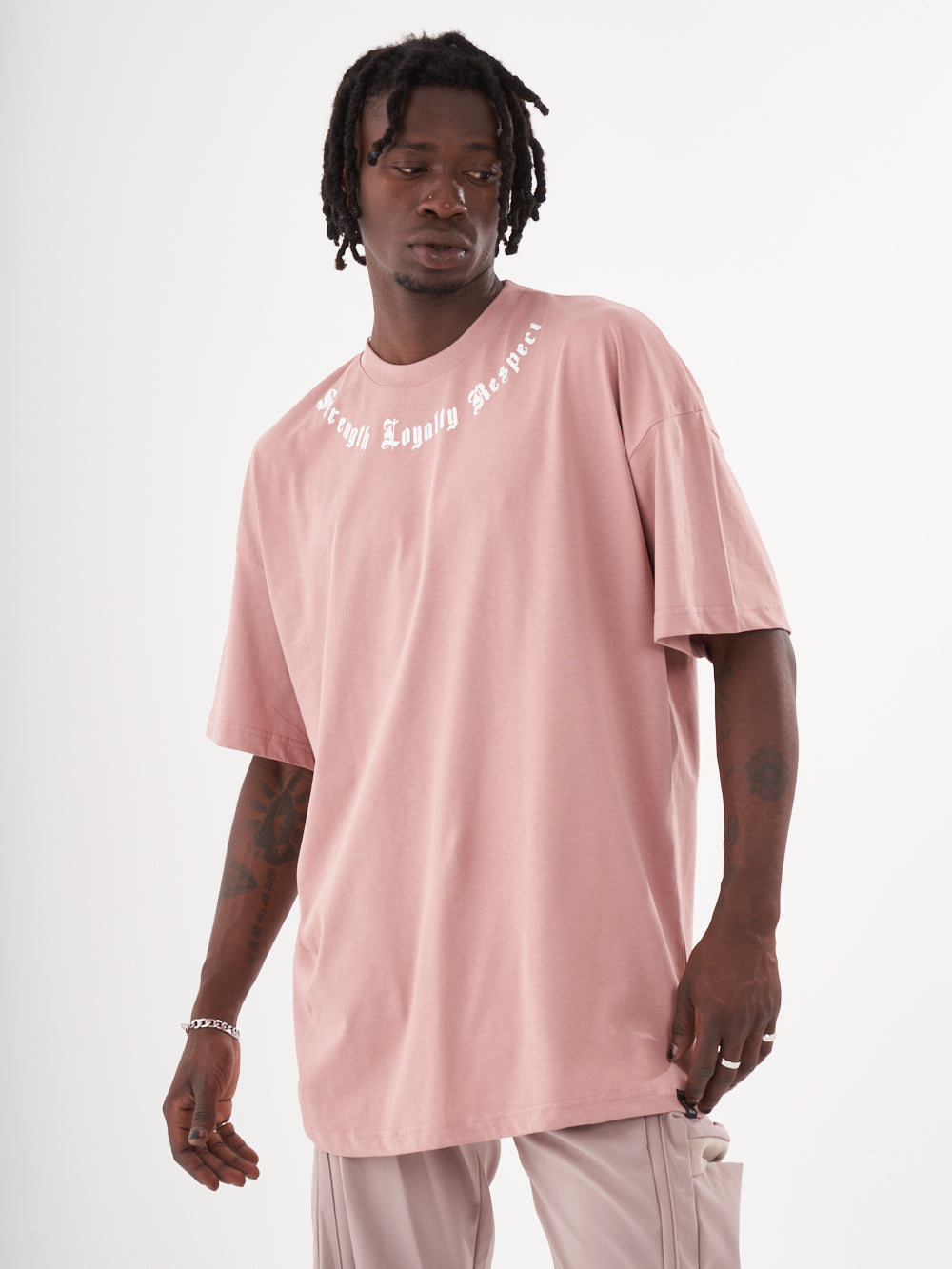 A man wearing a CREED T-SHIRT and pants.