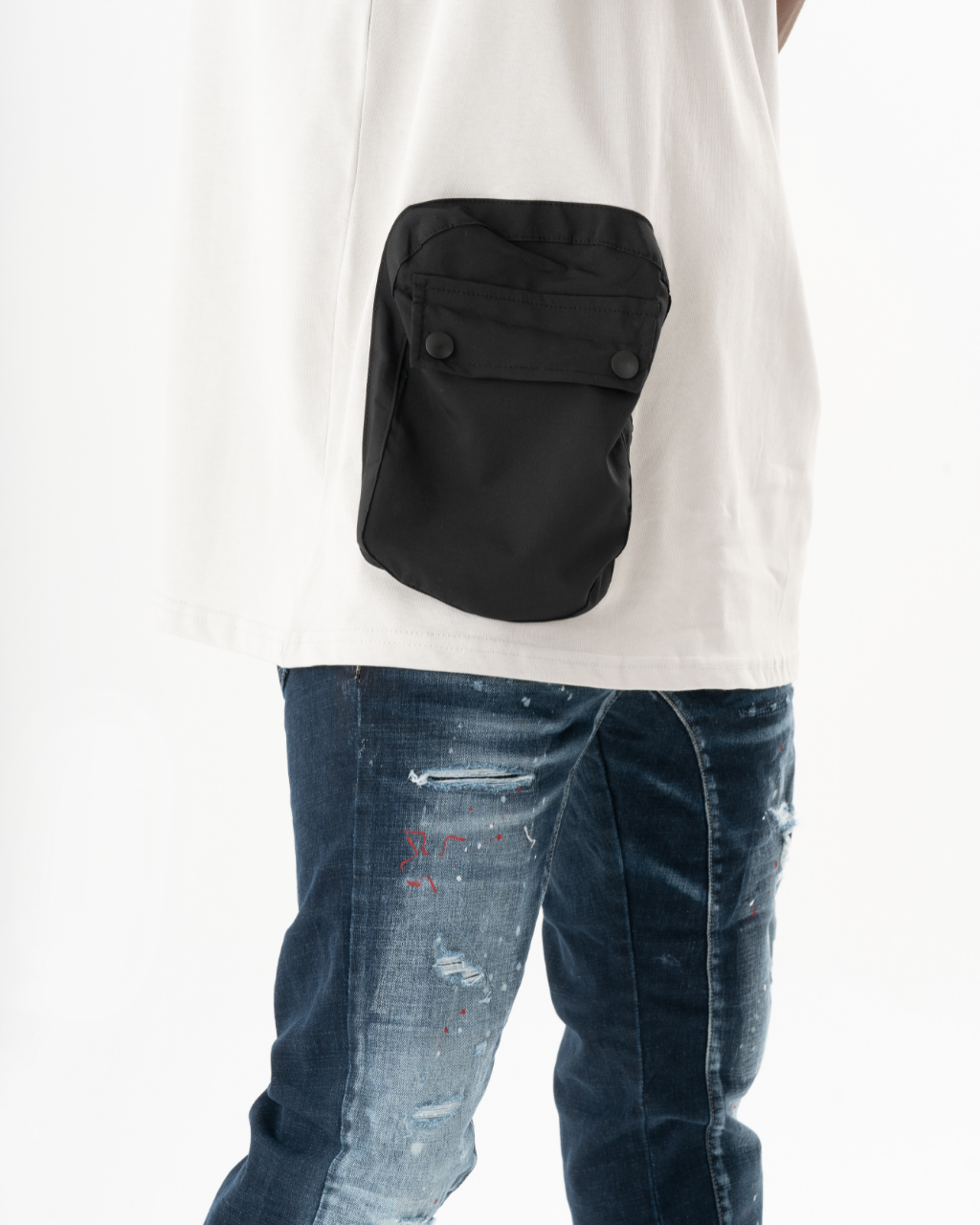A man wearing an ELEVATE t-shirt and jeans with a black pocket.