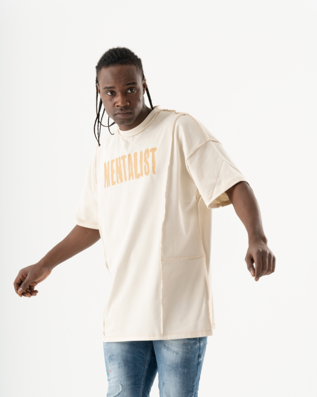 A man wearing a Mentalist T-shirt | Beige and jeans.