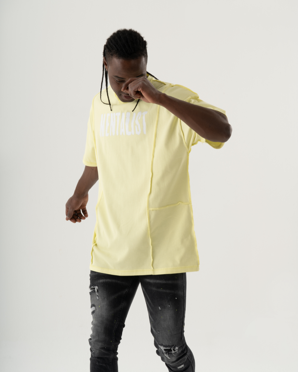 A man wearing a MENTALIST T-SHIRT | LIME and black jeans, giving off a summery vibe.