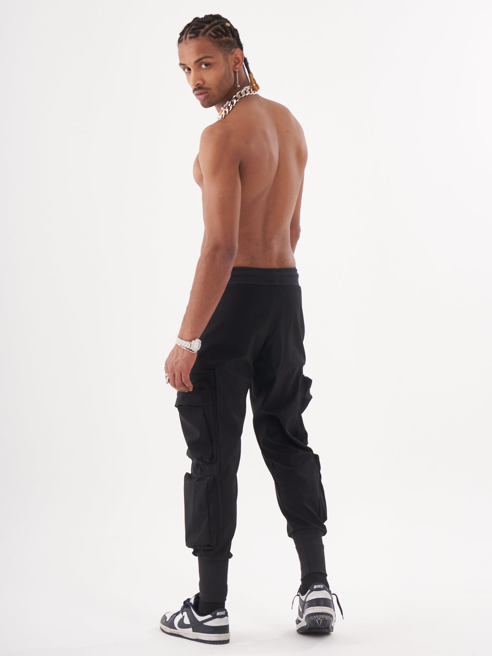 The back of a man wearing OUTLIER JOGGERS | BLACK cargo pants.