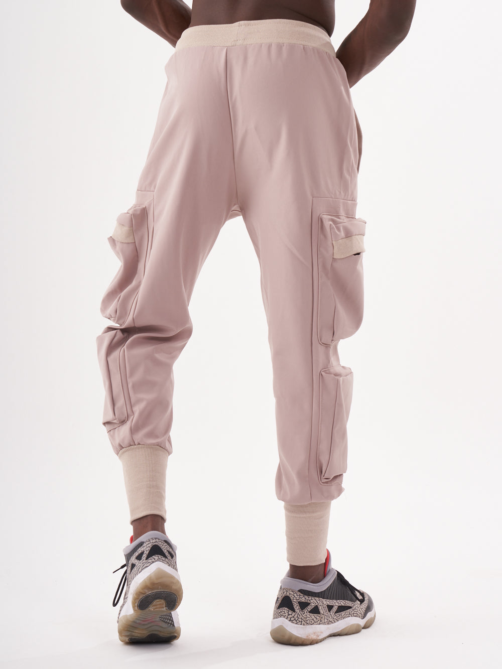 The back view of a man wearing OUTLIER | MAUVE cargo pants.