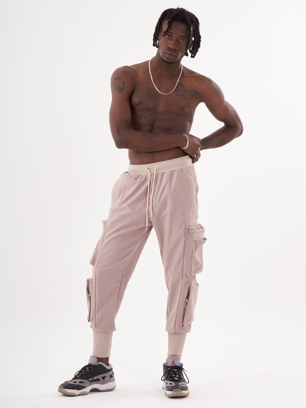 A man in OUTLIER | MAUVE cargo pants posing for a photo.
