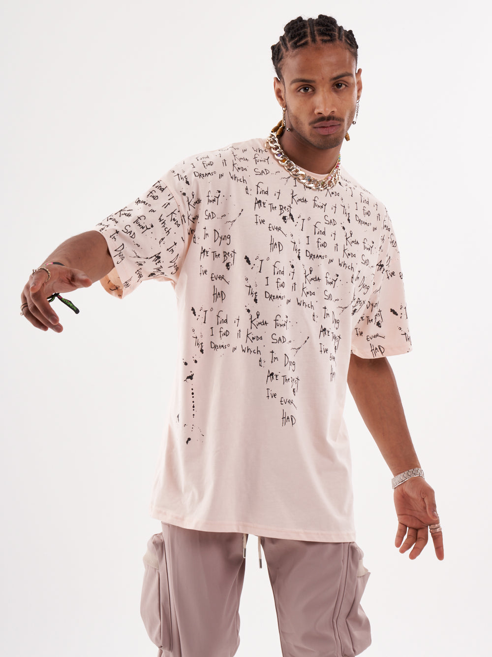 A man wearing a pink THINKER T-SHIRT with writing on it.
