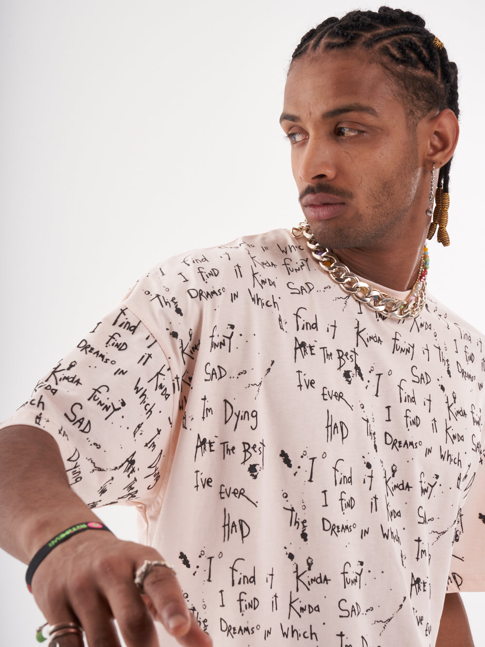 A man with dreadlocks wearing a THINKER T-SHIRT with writing on it.