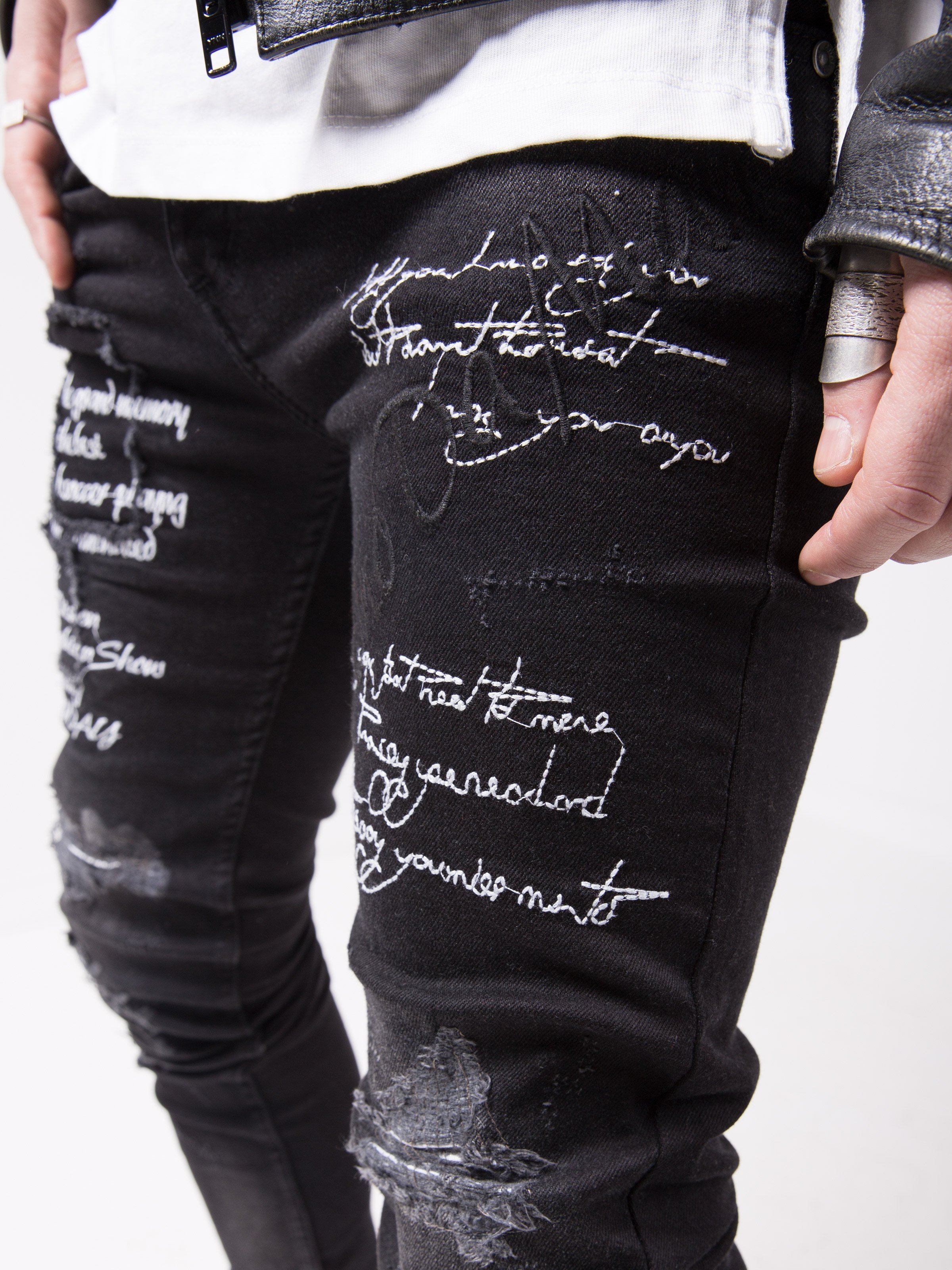 A man wearing a pair of BLACK STONE jeans with writing on them.