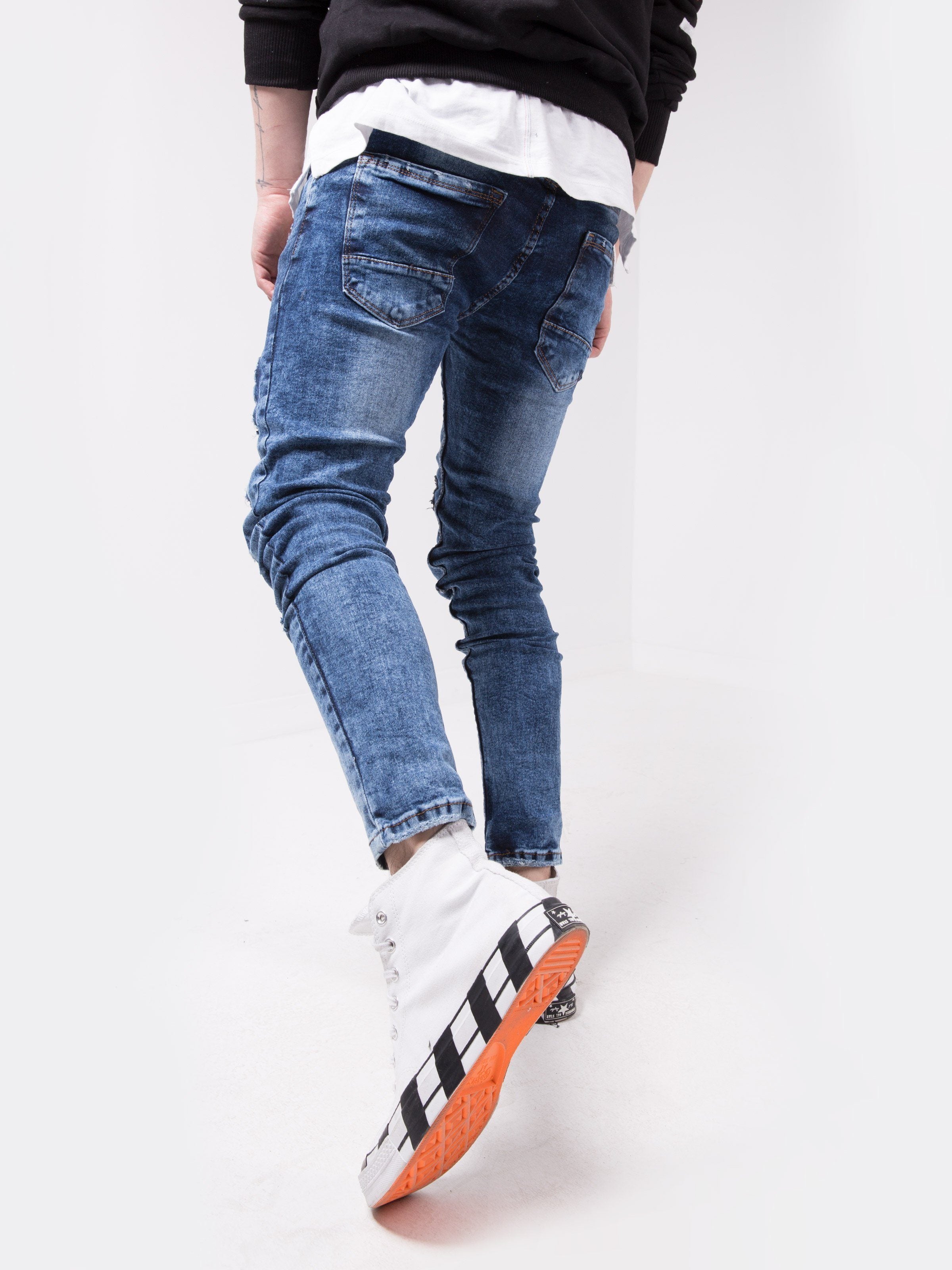 A man wearing jeans and sneakers standing on a white MOUNT EVEREST background.