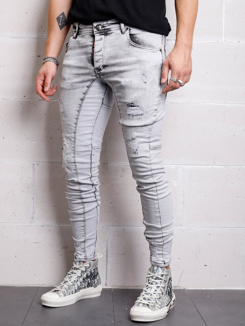 A man wearing distressed grey CLOUD 9 jeans.