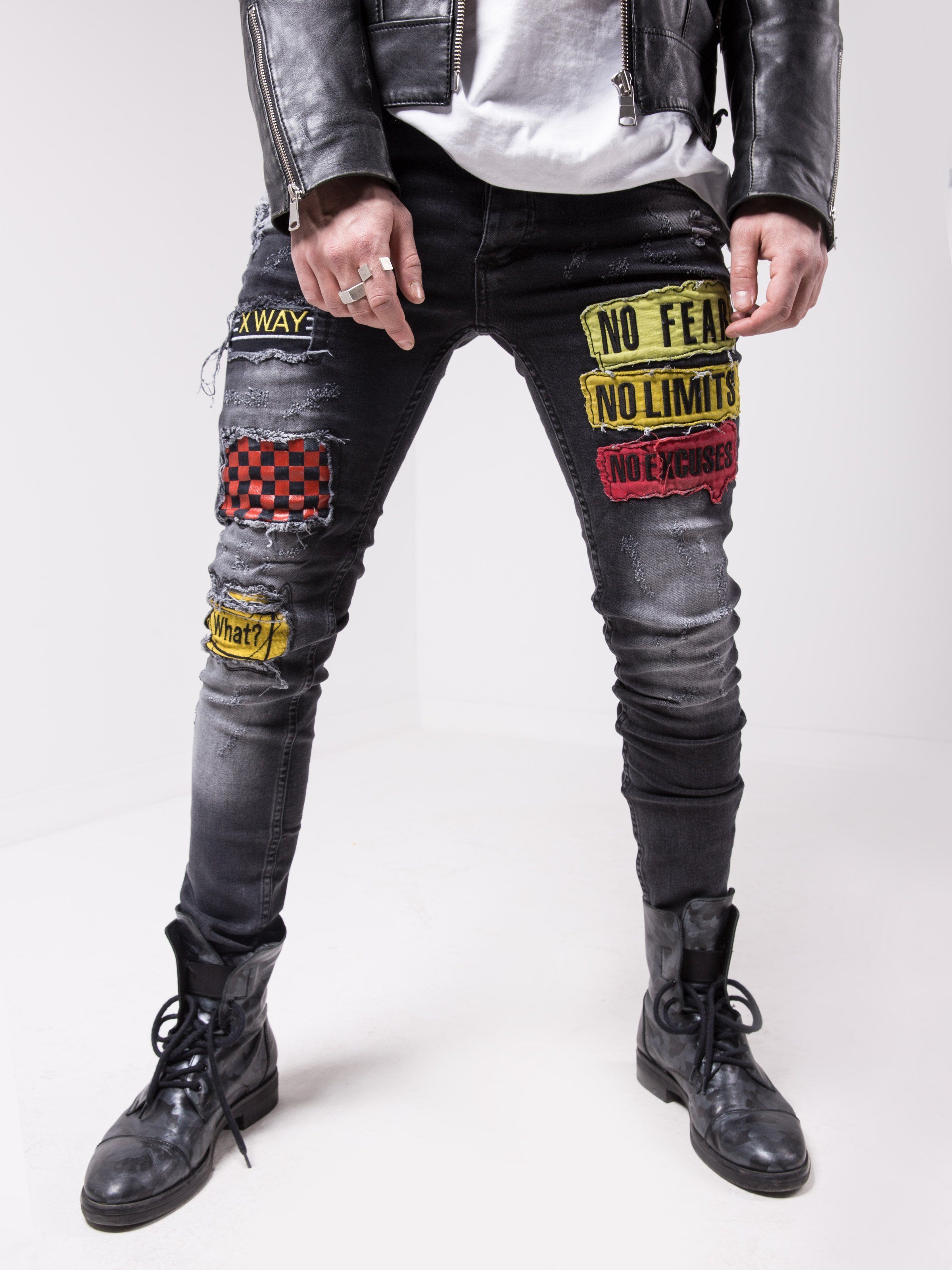 A man wearing FEARLESS skinny fit jeans with patches on them, providing a smooth feel and made of elastic fabric.