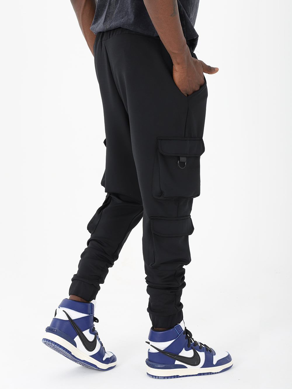 A man wearing black Ventura joggers and sneakers.