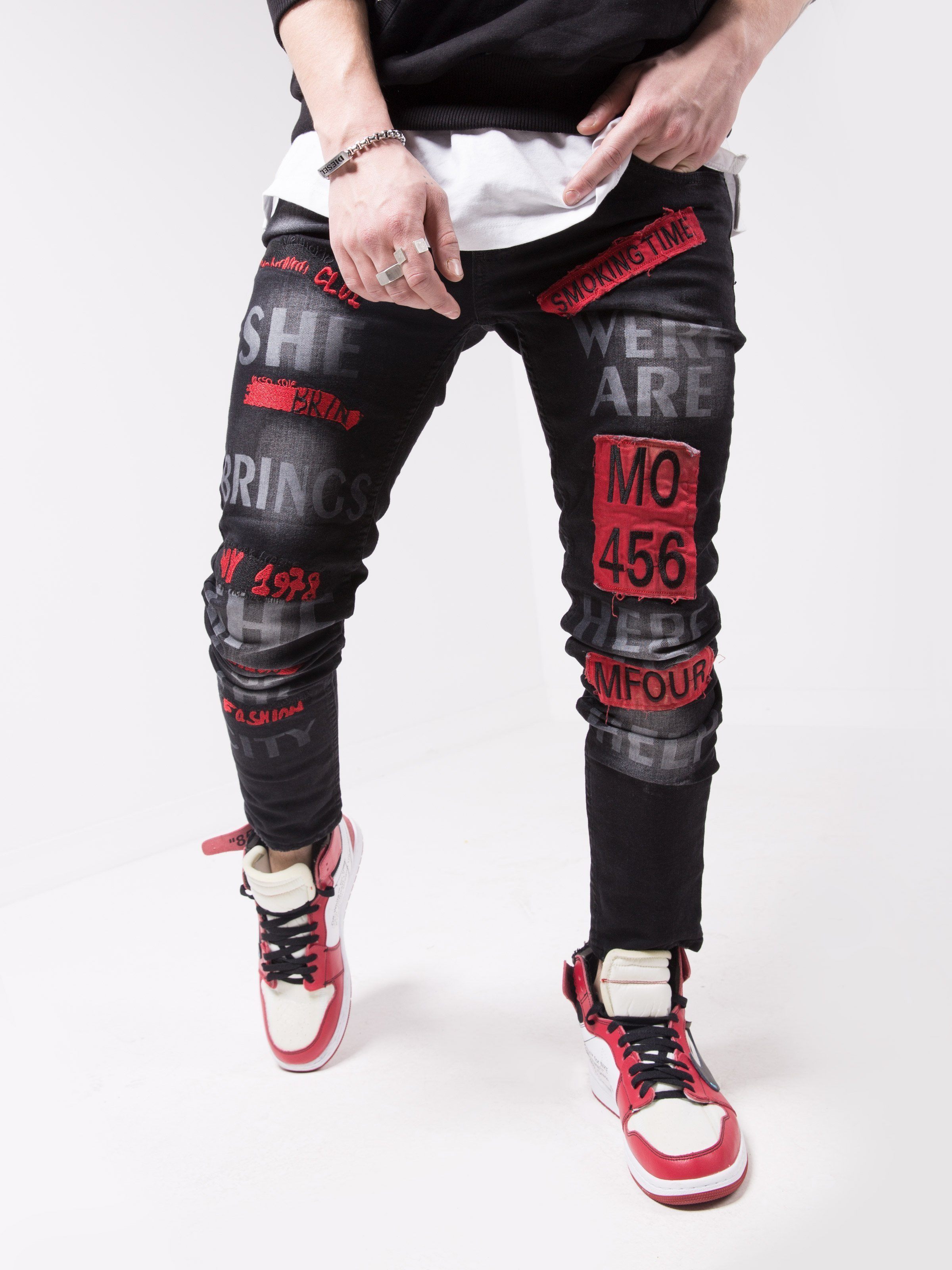 A man wearing a pair of GHETTO BIRD with red and black stripes.