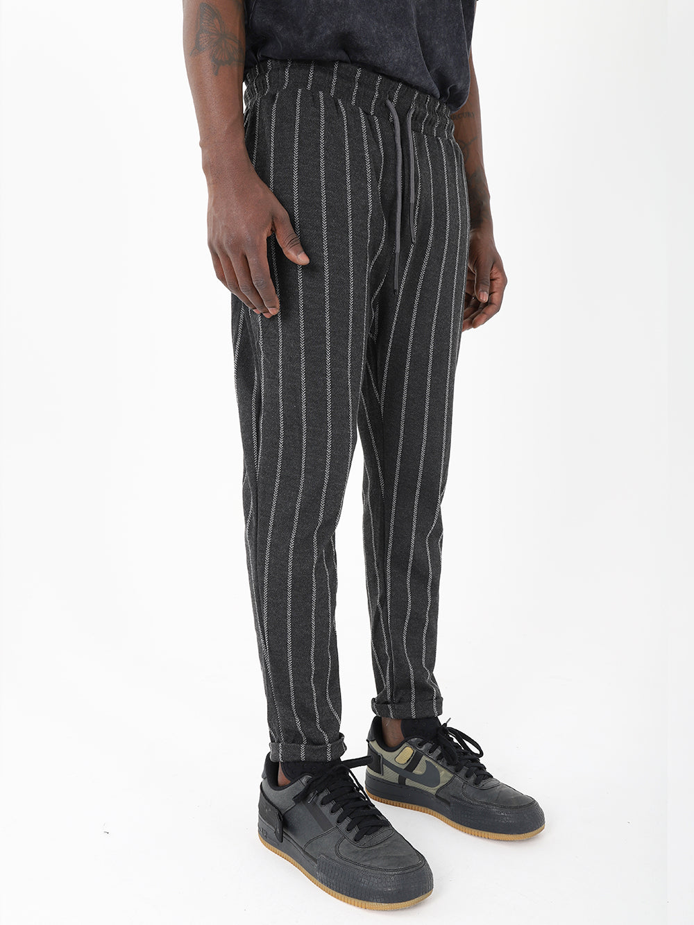 A man wearing POLARITY JOGGERS, black and white pinstripe jogger pants.