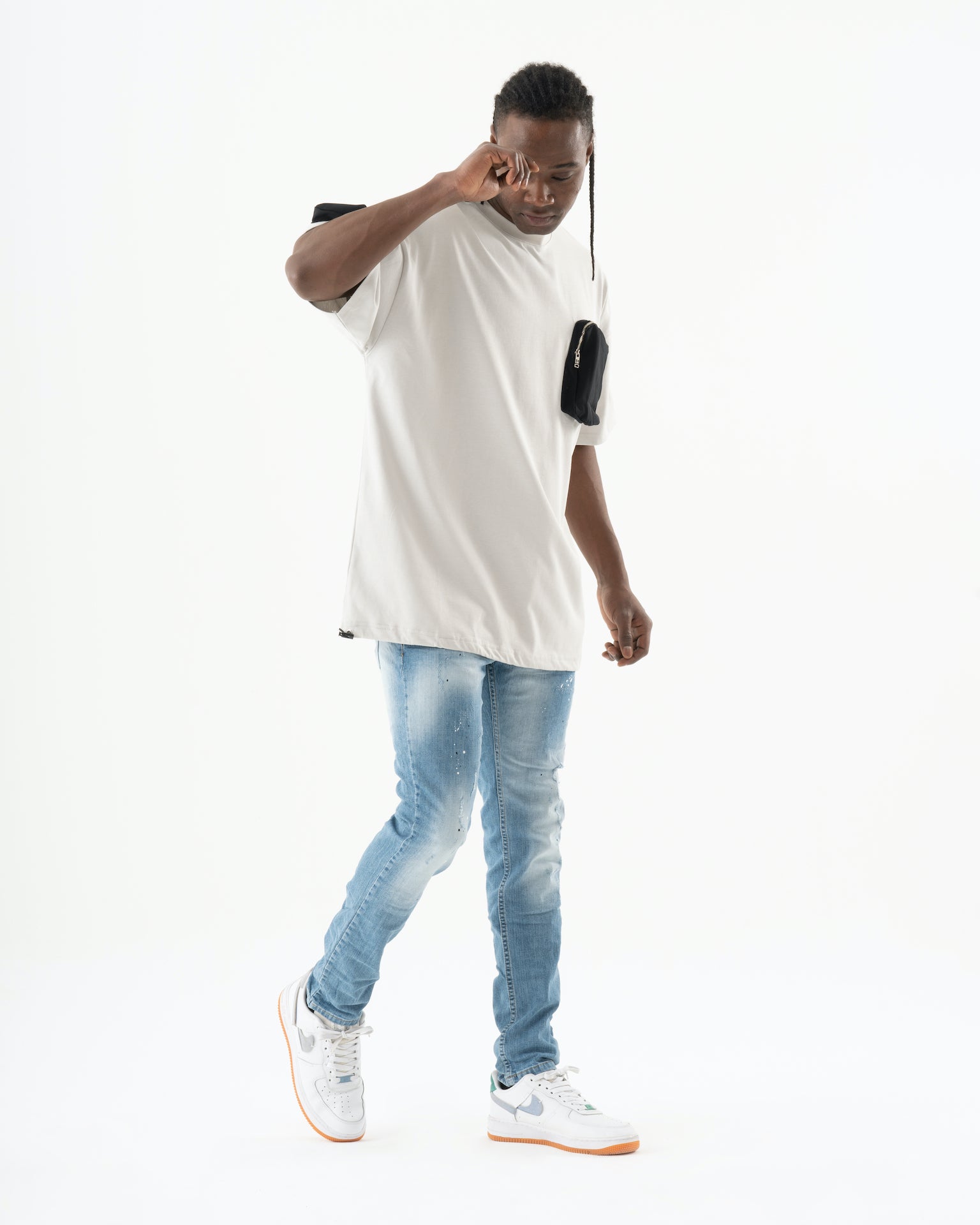 A man wearing a SKATER shirt and ripped jeans.