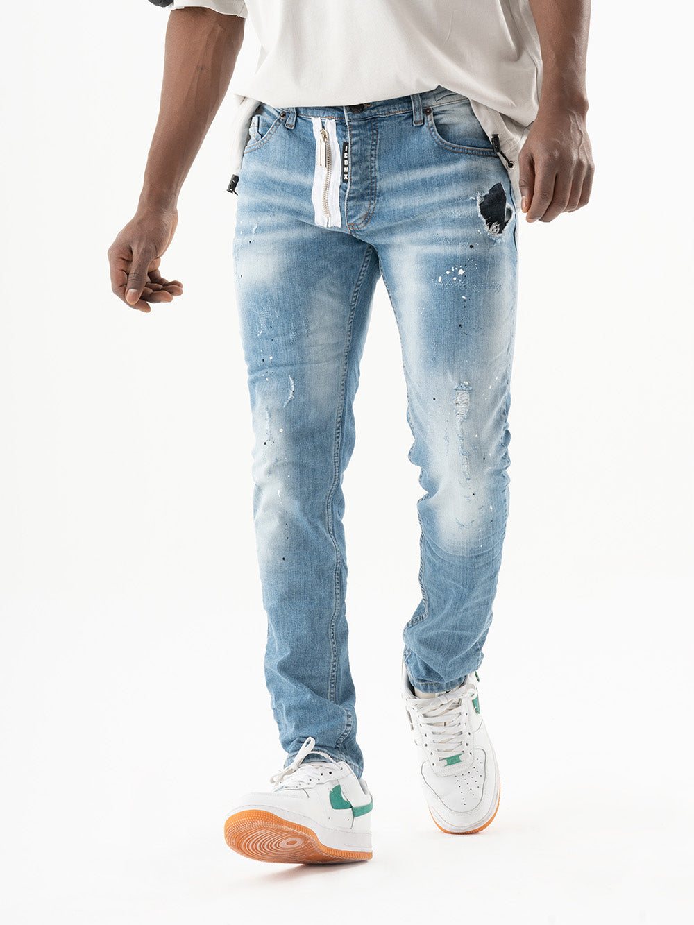 A man wearing a SKATER t - shirt and blue jeans.