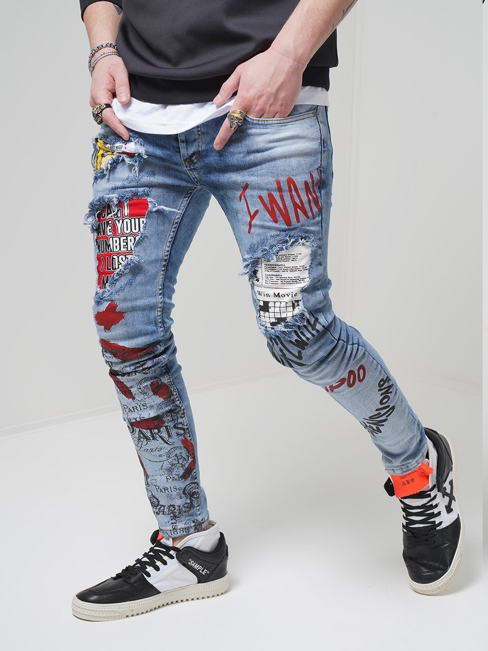 A man wearing a pair of BANKSY jeans with graffiti on them.