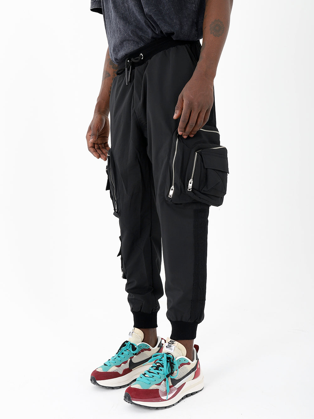 A man wearing black LAVANO JOGGERS and sneakers.