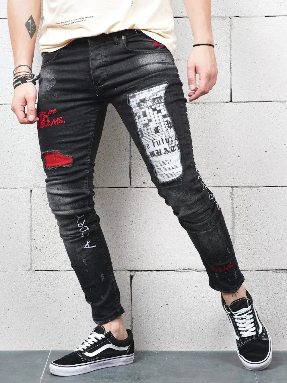 A man wearing black jeans with red patches called SKYSCRAPER.