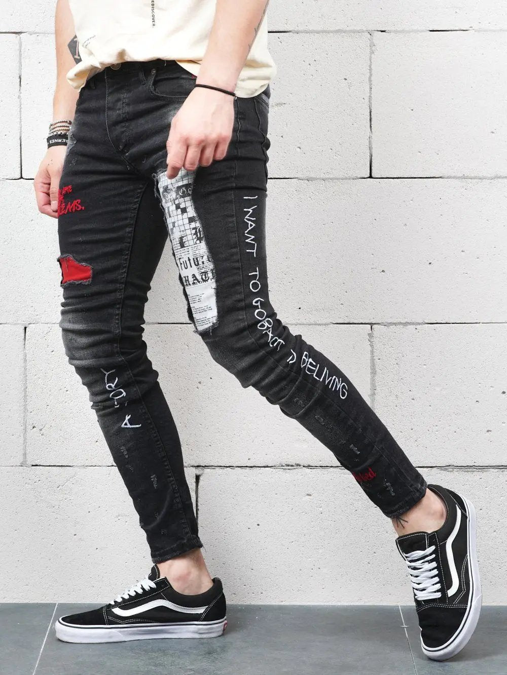 A man wearing a pair of black SKYSCRAPER with graffiti on them.