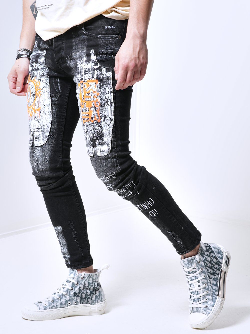 A man wearing a pair of SIXTY SIX jeans and sneakers.