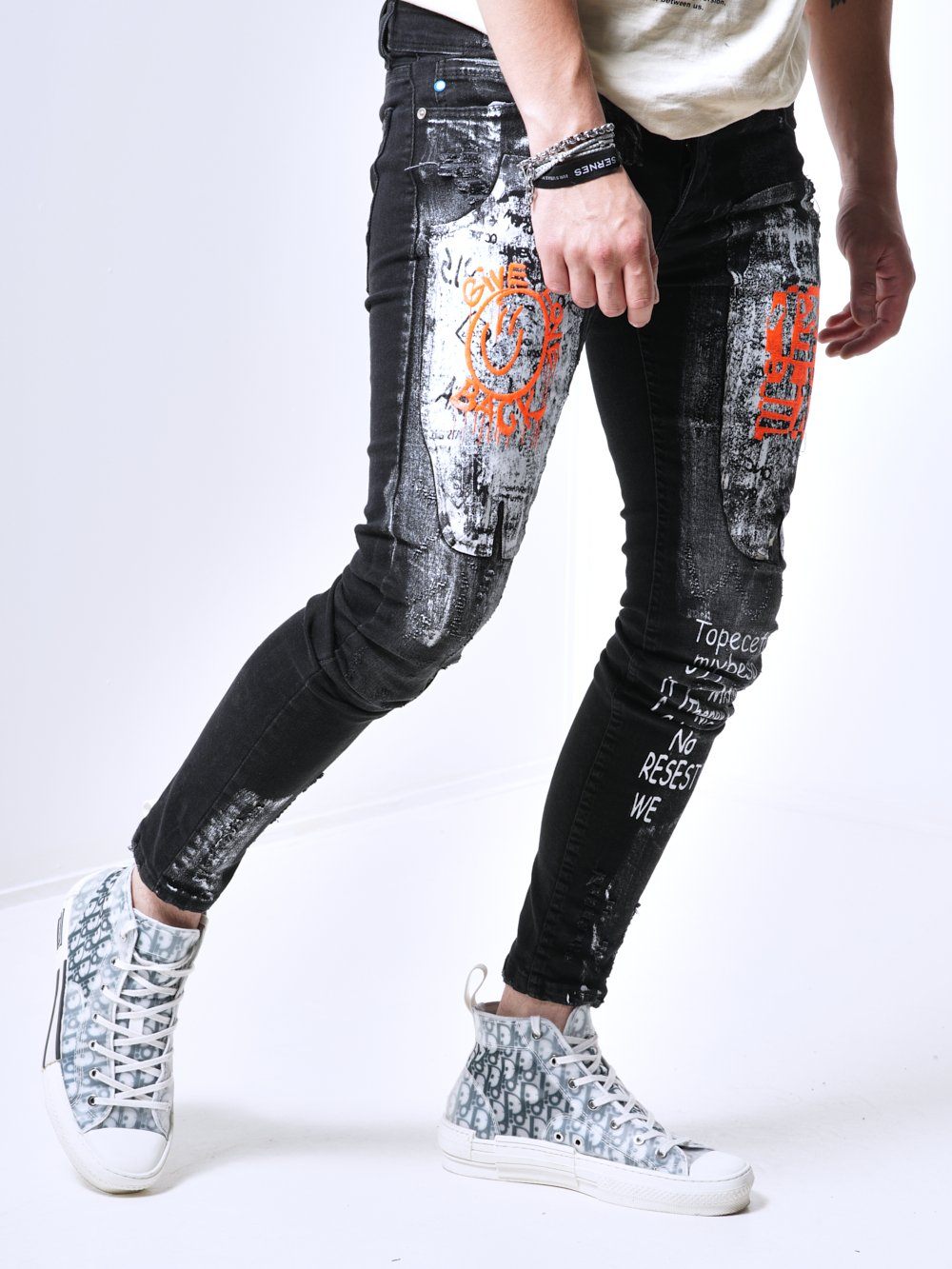 A man wearing a pair of SIXTY SIX jeans and sneakers.