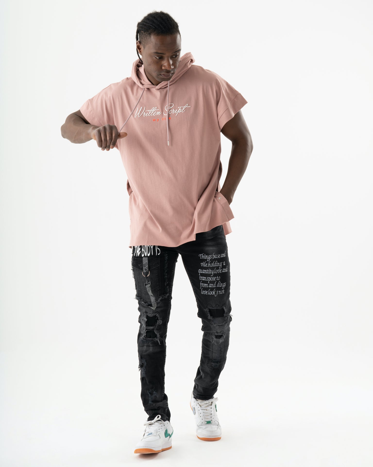 A man wearing a ONE SOUL pink hoodie and black jeans.