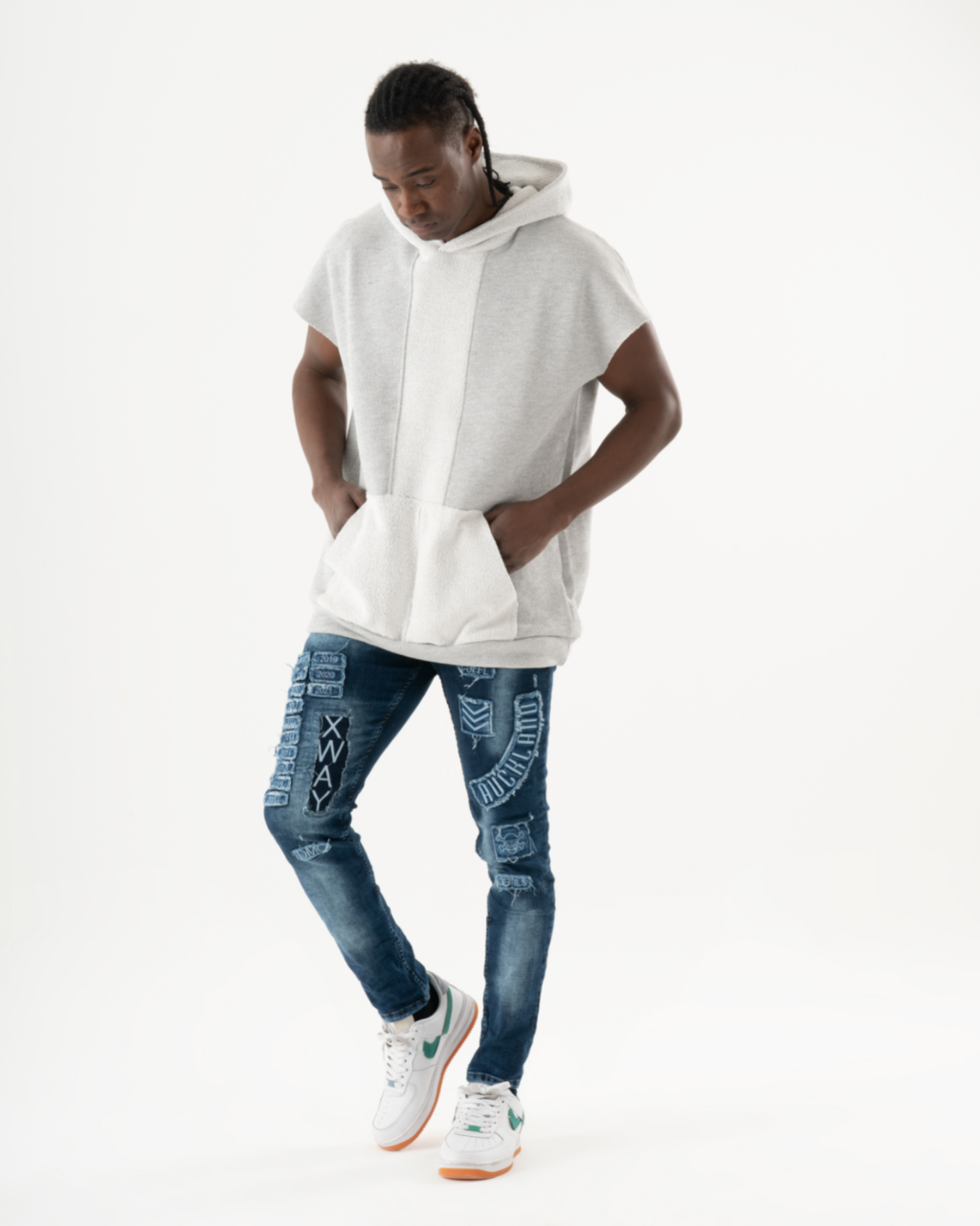 A man wearing INJUN | BLUE skinny jeans and a white hoodie.