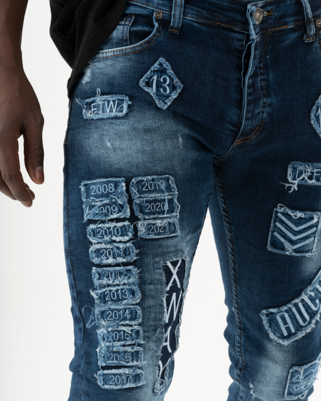A man wearing INJUN | BLUE jeans in a skinny fit, showcasing mens streetwear fashion.