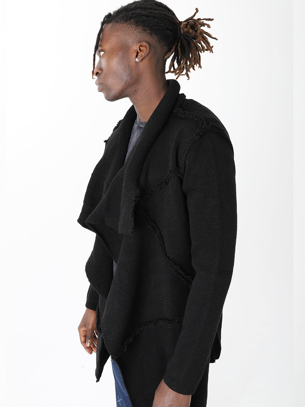 A man with dreadlocks wearing a HOODED DISTRESSED CARDIGAN // BLACK and skinny fit jeans, showcasing mens streetwear fashion.