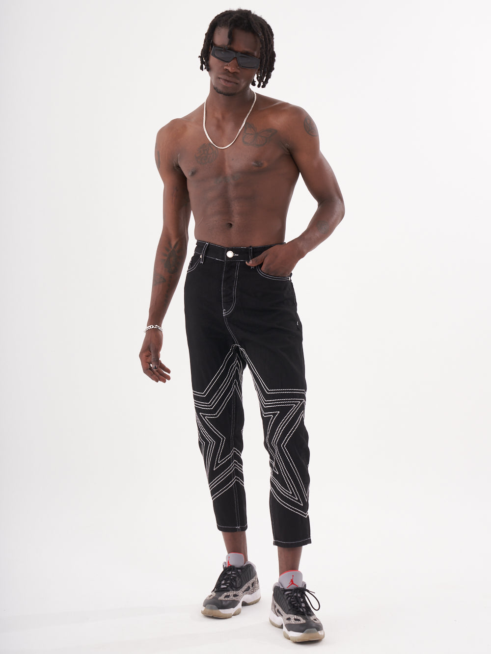 A man in black jeans with STARDOM on them.