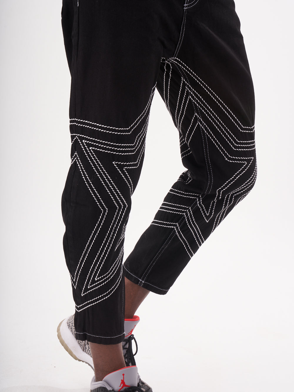 A man wearing STARDOM jogging pants.