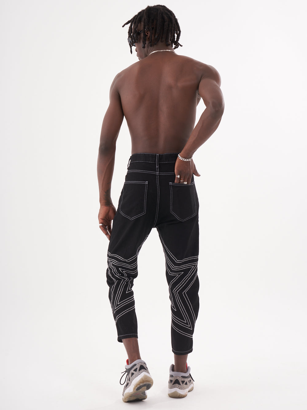 The back view of a man wearing STARDOM jogging pants.